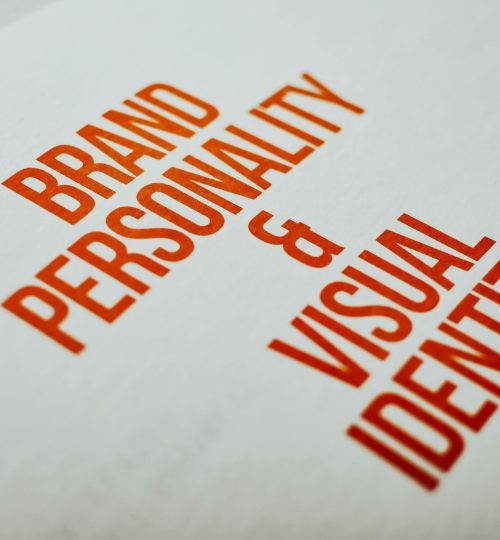 Close-up of 'Brand Personality & Visual Identity' text in red on white paper.